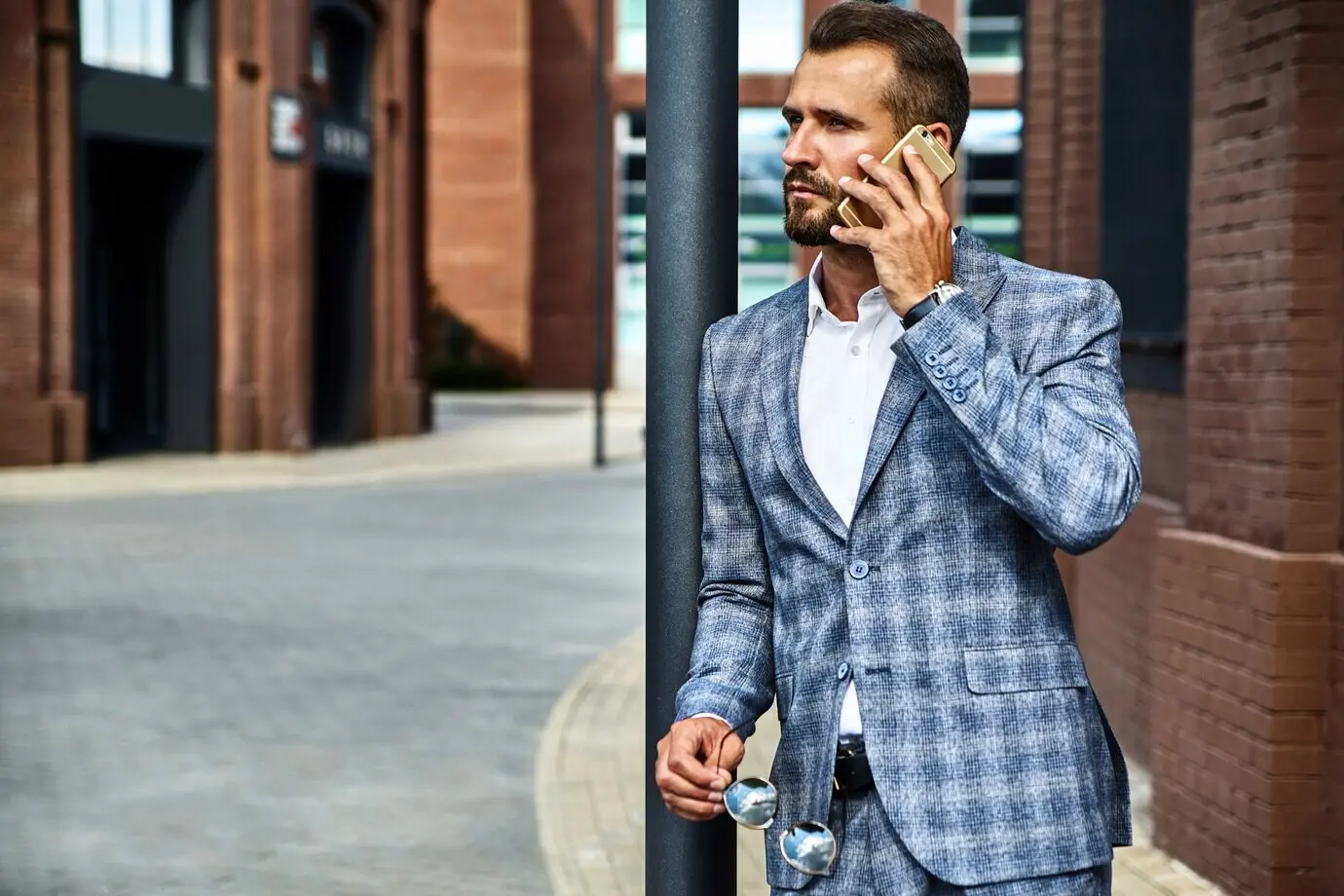 Portrait of a handsome fashion businessman model wearing an elegant checkered suit